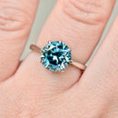 Ring with a blue gemstone on a finger