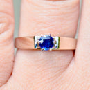 white gold ring with blue sapphire on a ring finger