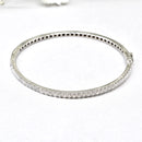 white gold bangle with clear diamonds on a white background