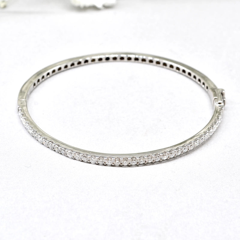 white gold bangle with clear diamonds on a white background