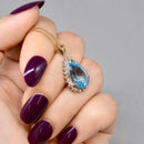 Swiss Blue Topaz and Diamond Halo Pendant With 9ct Yellow Gold Chain