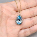 Swiss Blue Topaz and Diamond Halo Pendant With 9ct Yellow Gold Chain