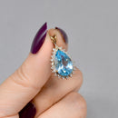 Swiss Blue Topaz and Diamond Halo Pendant With 9ct Yellow Gold Chain