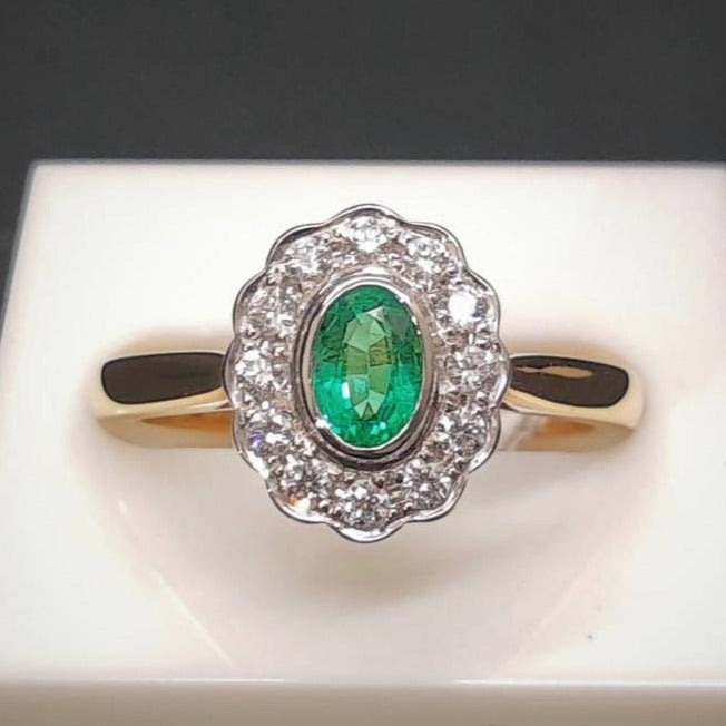 emerald and diamond cluster style engagement gold ring